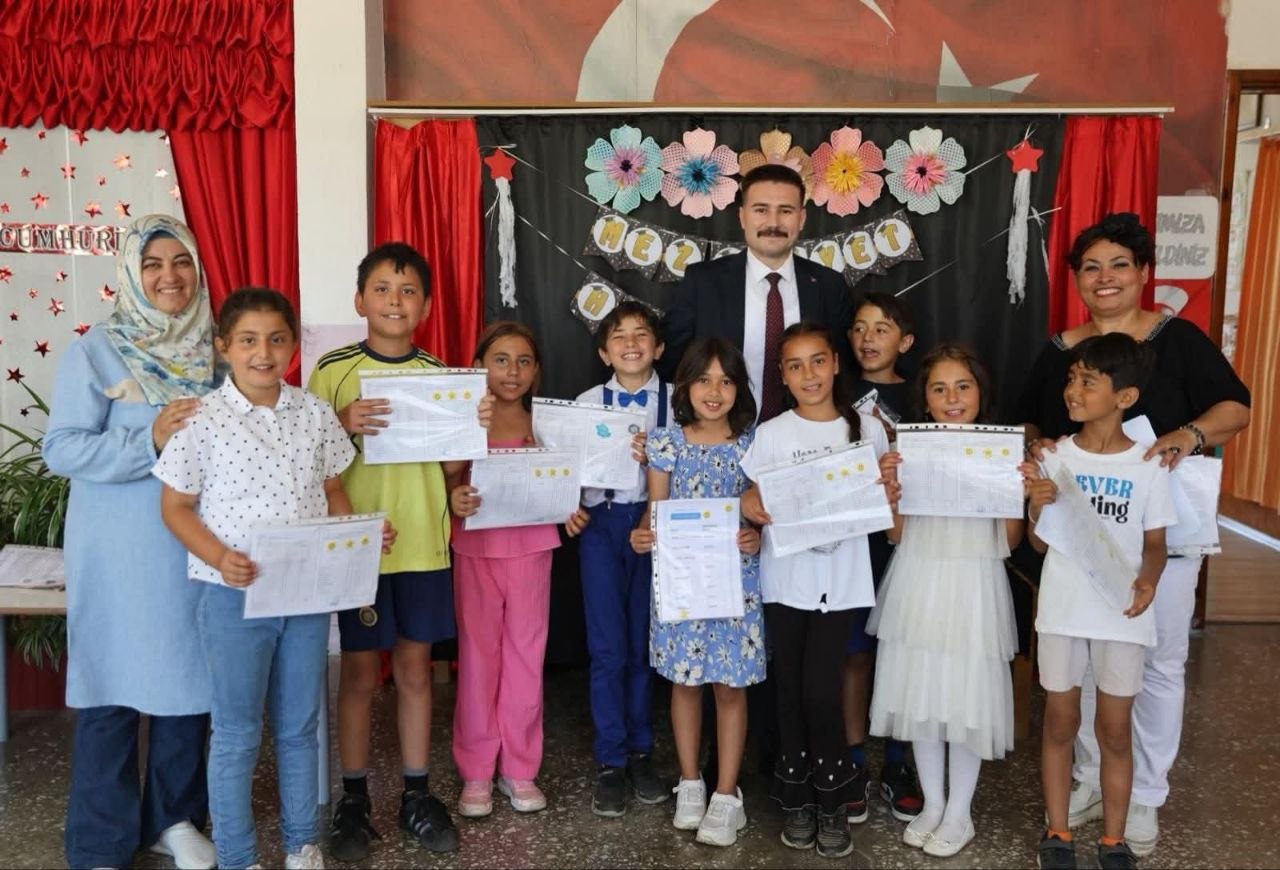 Kaymakam Osman Acar Gökçeada Ortaokul'nda öğrencilere karne verirken